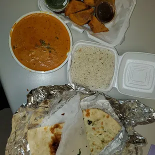 a plate of naan, rice, curry, and naan bread