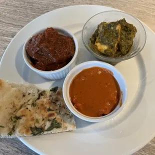 Takeout- basil garlic naan, lamb vindaloo, butter chicken, and saag paneer