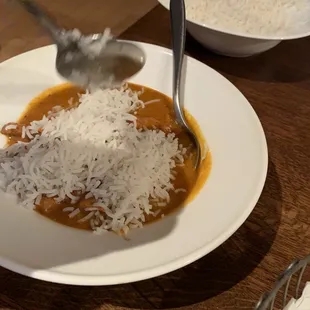 a plate of food with rice and a spoon