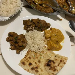 a plate of indian food with rice and naan bread