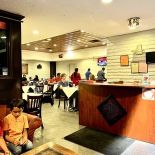 two children sitting on a couch in a restaurant