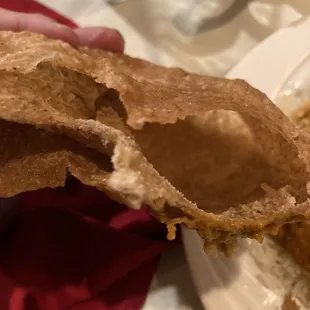 a hand holding a piece of bread