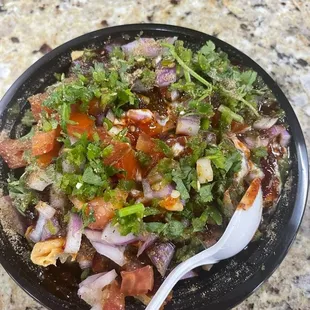 a black plate with a salad on it