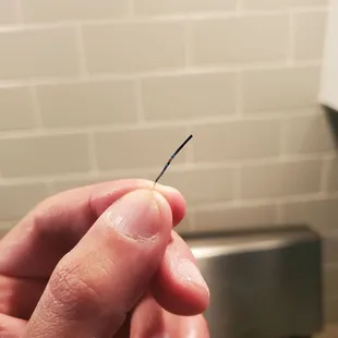 a person holding a needle in their hand