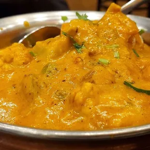 a bowl of curry with a spoon in it