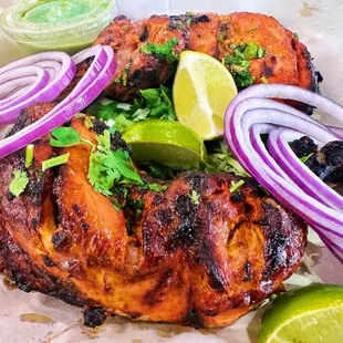 grilled chicken with onions and lime wedges