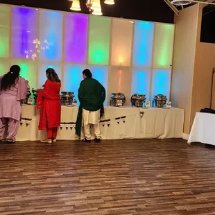 a group of people standing around a buffet table