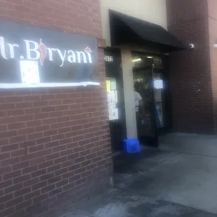 Entrance has "Mr. Biryani" poster next to it.