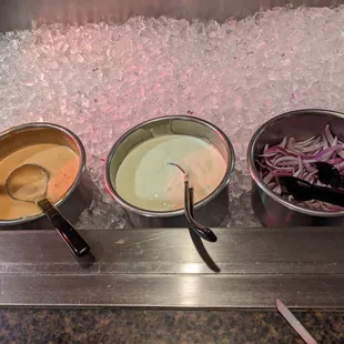 three bowls of food on ice