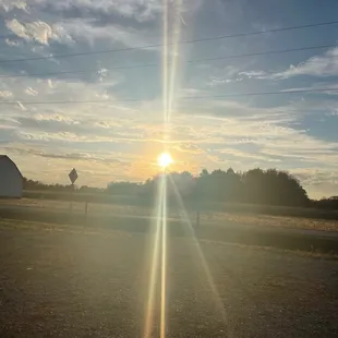 the sun setting behind a barn