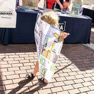 a young boy in a newspaper bag