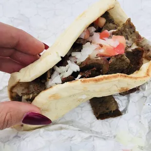 The gyros are delicious and packed with lamb! They come with tzatziki sauce, tomatoes, and onions on top, but you can customize your gyro!