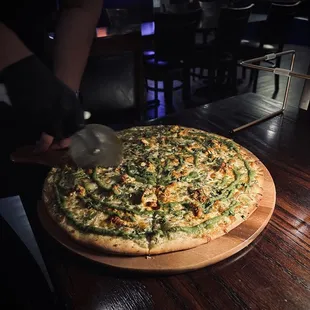 a person cutting a pizza