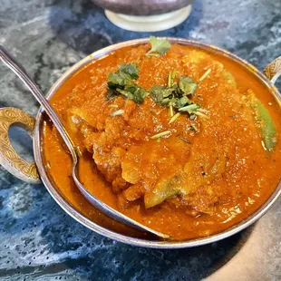 a bowl of curry with a spoon