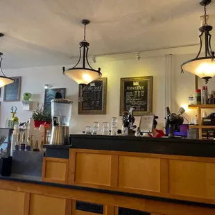 a bar with a black counter and light fixtures
