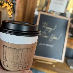 a hand holding a cup of coffee