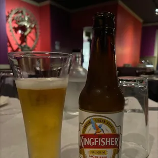 a glass of beer and a bottle of kingfisher