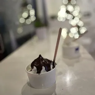 a cup of ice cream with chocolate and marshmallows