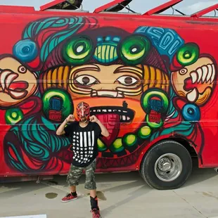 a man standing in front of a painted food truck