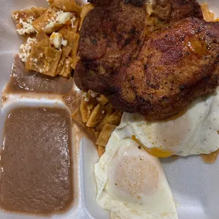 Pork chops with chilaquiles and over easy eggs