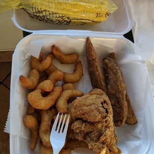 Fried shrimp, spicy chicken breast, potato wedges and corn on a cob