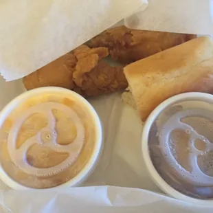 Two drumsticks, mac-n-cheese, mashed potatoes and gravy, and a roll.