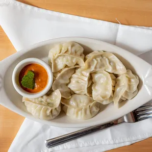 a plate of dumplings with sauce