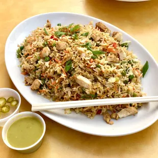 a plate of fried rice with chopsticks