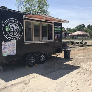 a food truck parked in a dirt lot