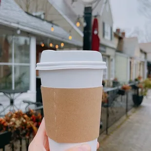 a hand holding a cup of coffee