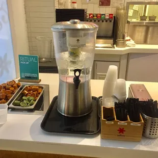 Condiments, utensils &amp; infused water (cuke &amp; lemon slices)