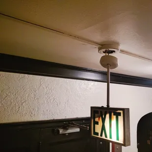 Emergency exit sign hanging by wires by the elevator door in the Marleigh.