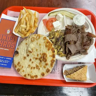 Dinner plate with lamb and chicken and a piece of Baklava.