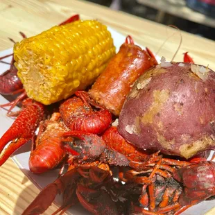 a lobster, corn and potatoes