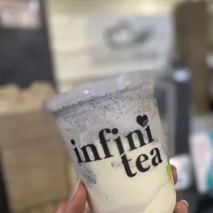 a hand holding a cup of iced tea