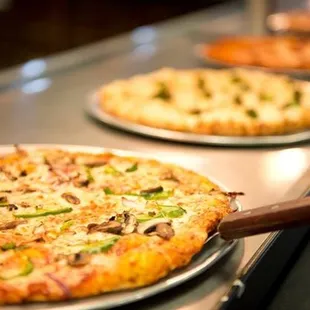 two pizzas on a counter
