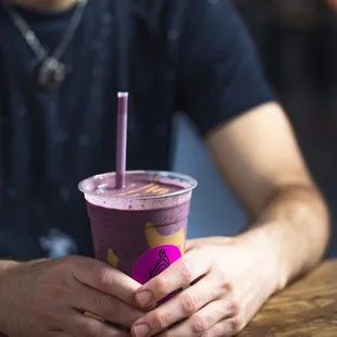 a man holding a purple smoothie