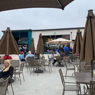 people sitting at tables with umbrellas