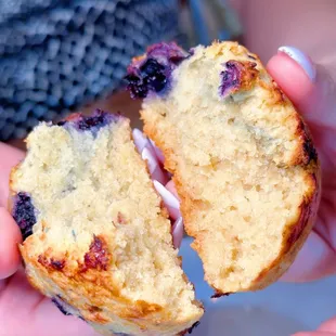 a person holding a half eaten muffin