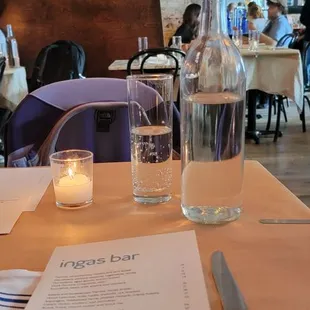 a glass of water and a menu on a table