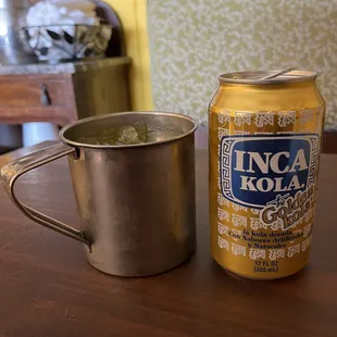 a can of beer next to a mug