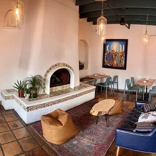 Fireplace with tables dispersed for dining.