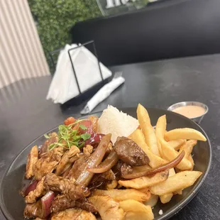Chicken and beef stew with white rice and fries.