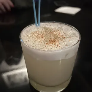 a drink in a glass with a blue straw
