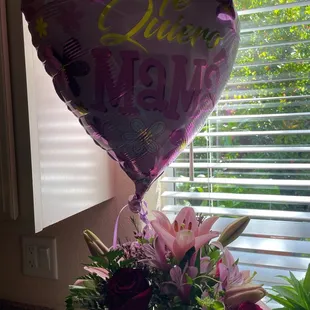 Flowers are wilted. The balloon is in Spanish. I'm not sure what it says.