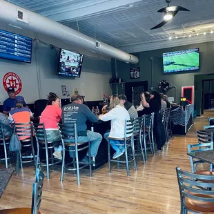 people sitting at tables watching tvs
