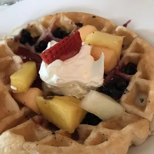 Homemade style waffles with additions like coconut and topped with fresh berry jam
