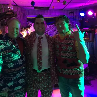 three people dressed in ugly sweaters