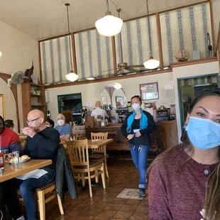 a woman wearing a face mask in a restaurant
