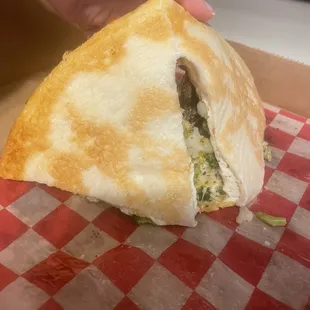 a hand holding a piece of pizza